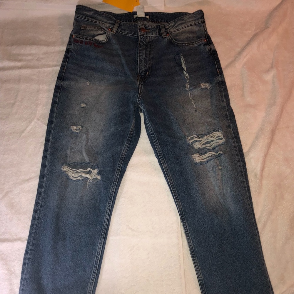 Distressed jeans w/ distressed bottom hem.